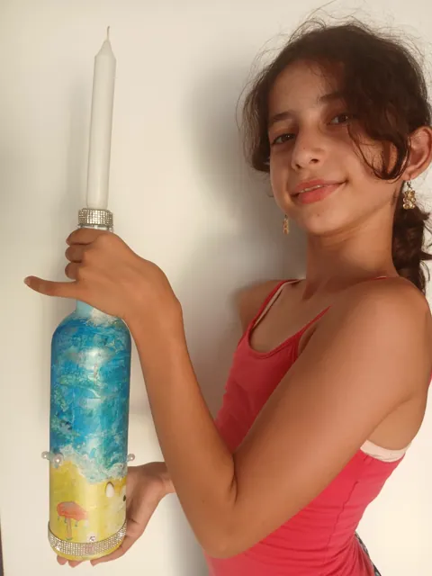 Girl showing the ribbon and pearl details on her bottle candle holder