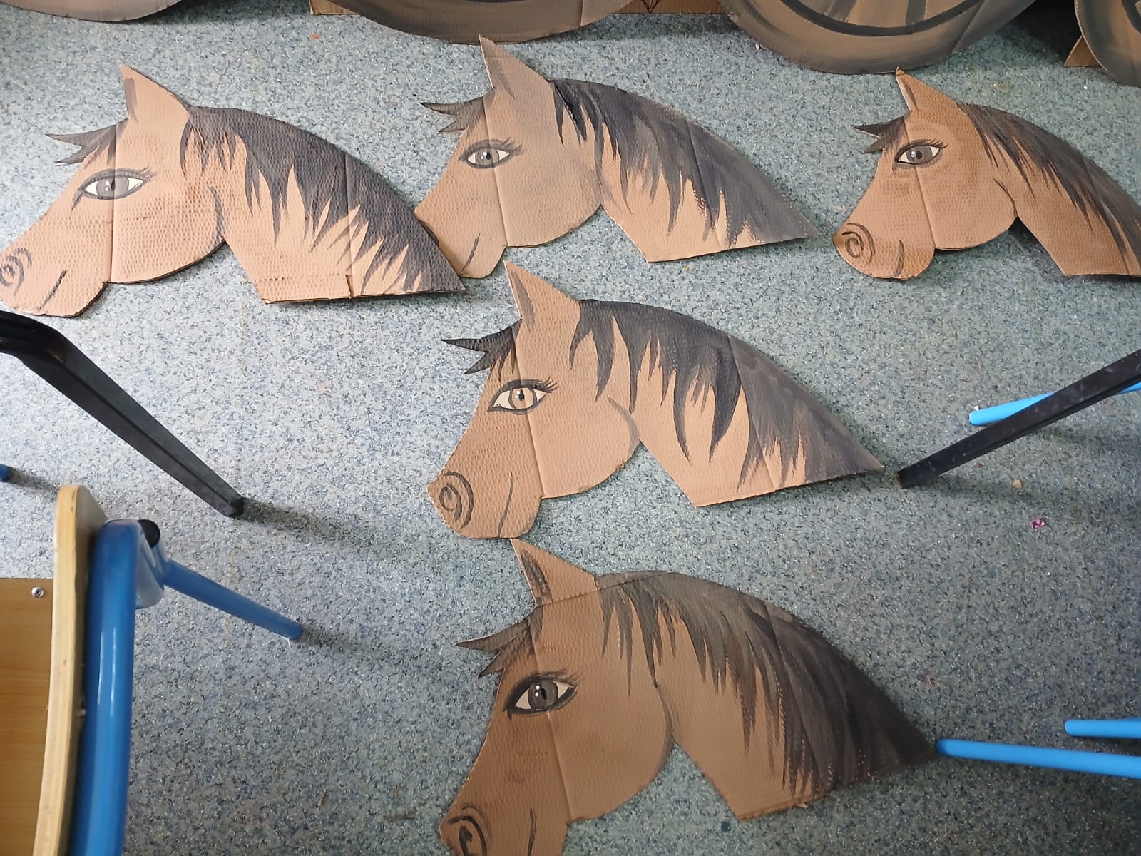 Cardboard horse head drawings on the floor