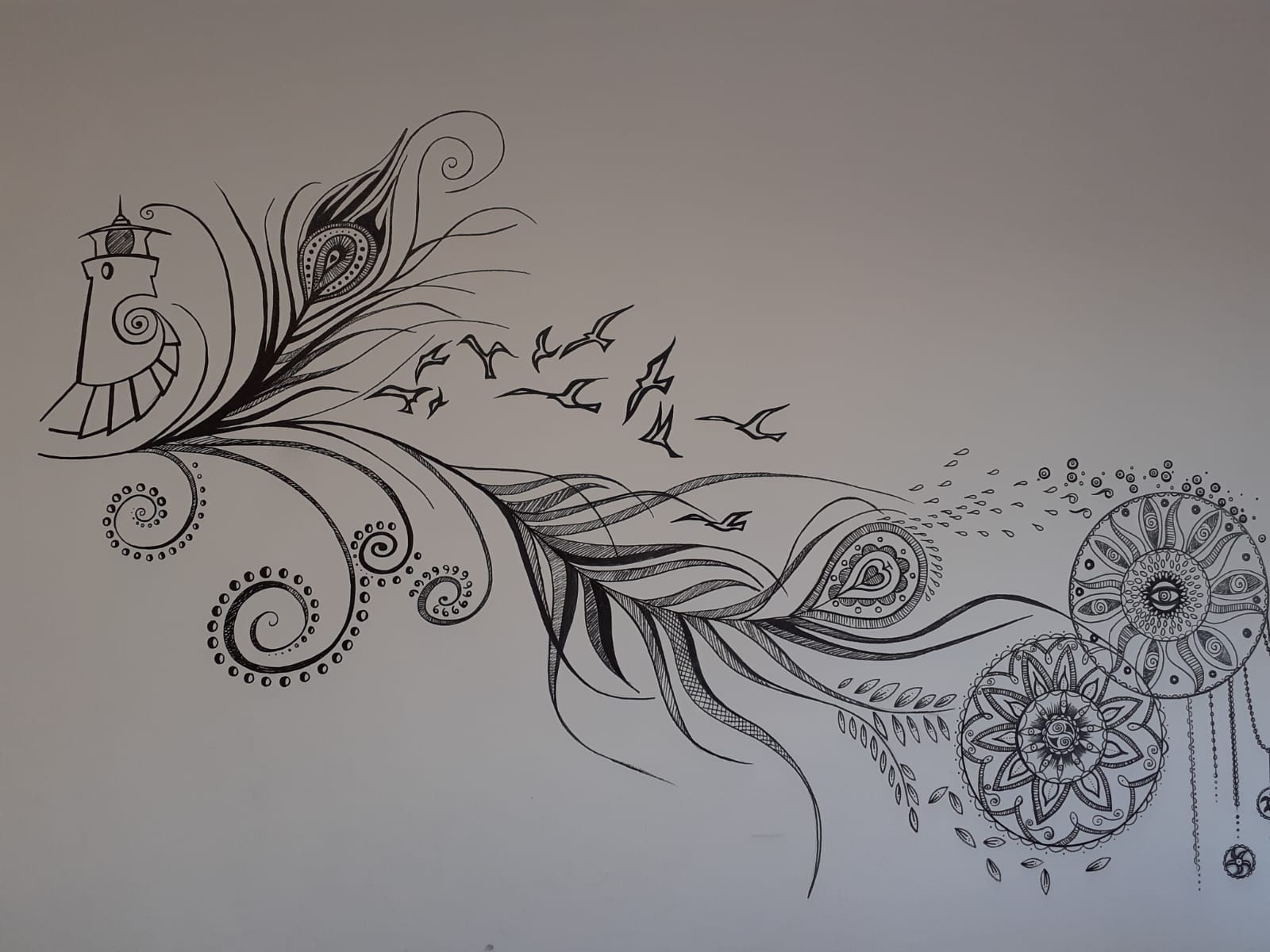 Black and white peacock-style wall drawing with decorative swirls