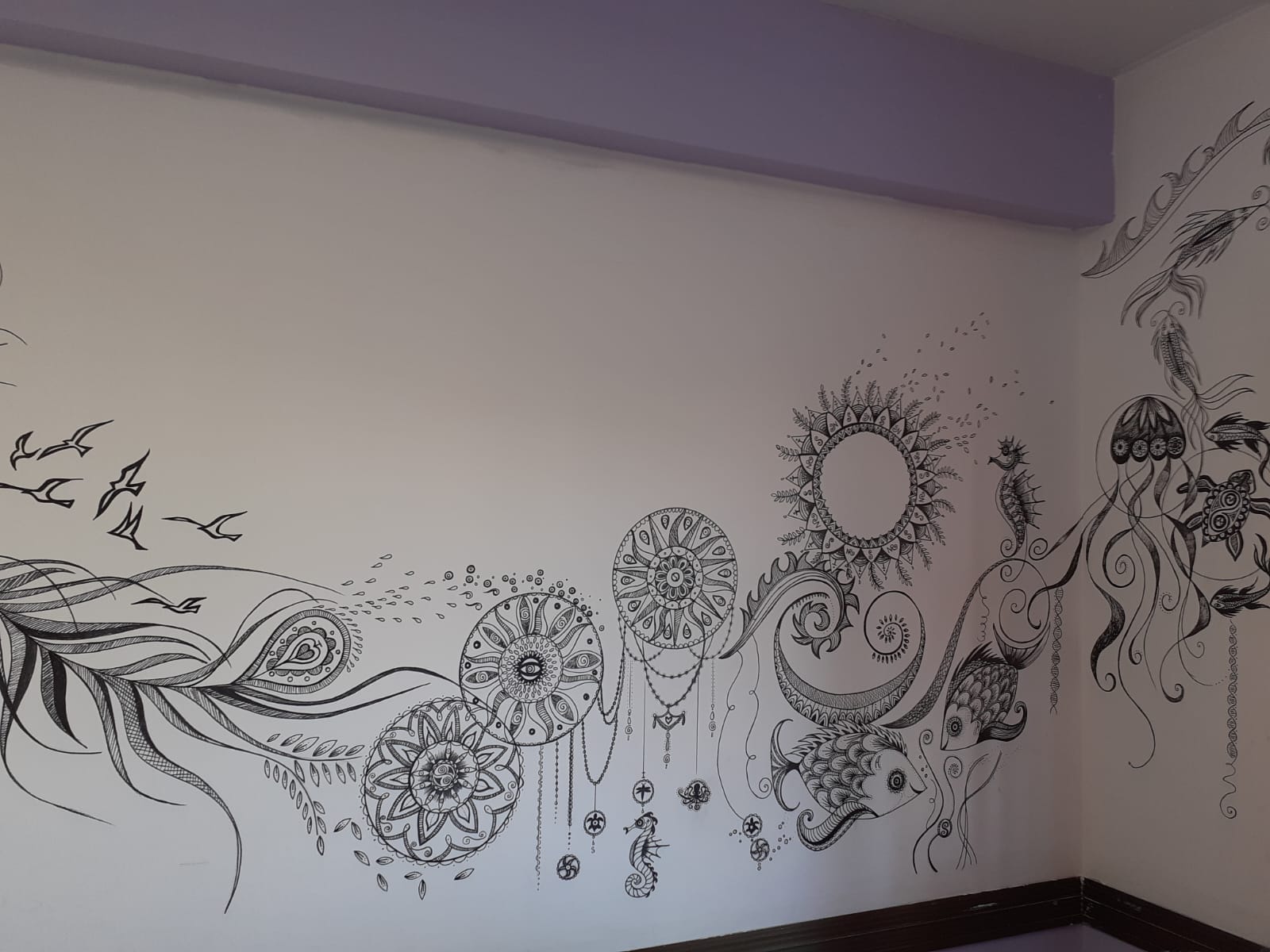 Wide wall mural of black and white sea and mandala drawings