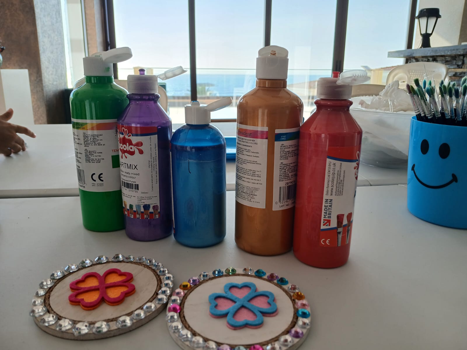 Paint bottles, brushes and finished heart hoop crafts