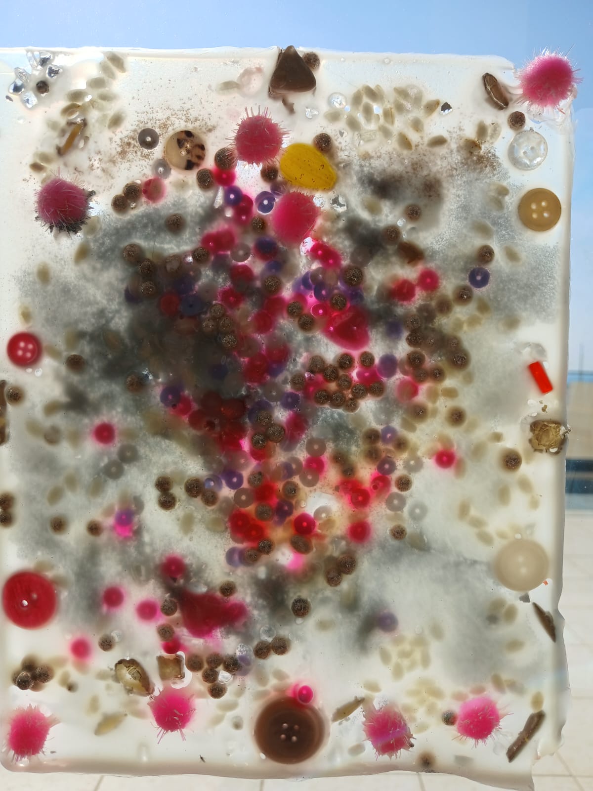 Close-up of a sensory panel with pink beads and soft pom-poms